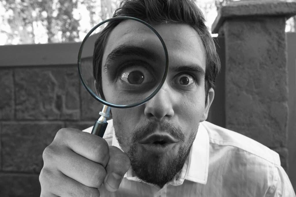 man looking through a magnifying glass